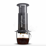 AeroPress coffee maker brewing black coffee into a clear glass cup