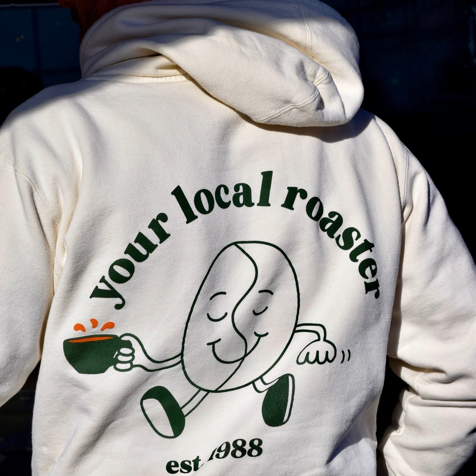 Coffee Tree Roastery hoodie with “your local roaster” bean character graphic on back