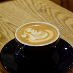 Latte with milk foam art in a ceramic cup, representing espresso-based coffee
