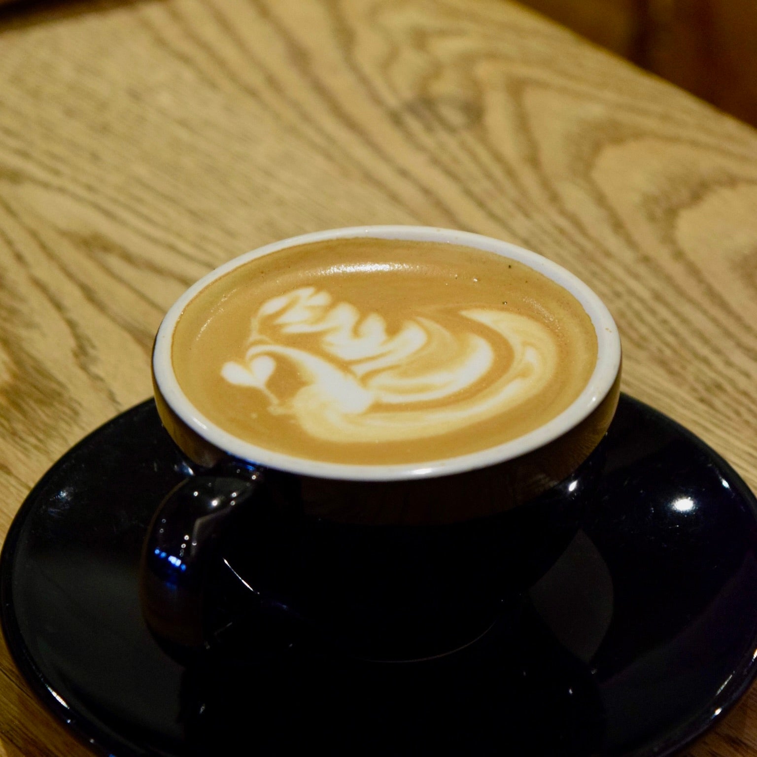Latte with milk foam art in a ceramic cup, representing espresso-based coffee