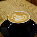 Latte with milk foam art in a ceramic cup, representing espresso-based coffee