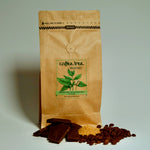 Bag of Millionaire’s Mixture dark roast coffee with chocolate and roasted nut flavour props arranged beside it