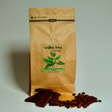 Bag of Millionaire’s Mixture dark roast coffee with chocolate and roasted nut flavour props arranged beside it